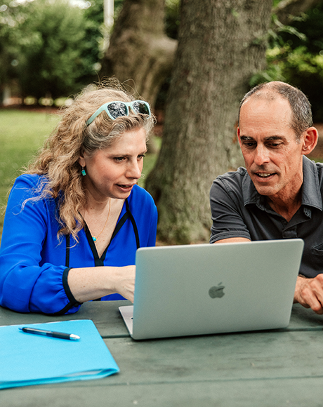 photo, two Hillside coaches looking at laptop and talking.