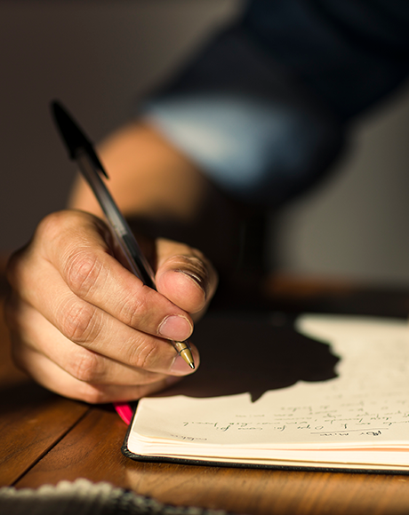 photo: close-up of hand writing in notebook