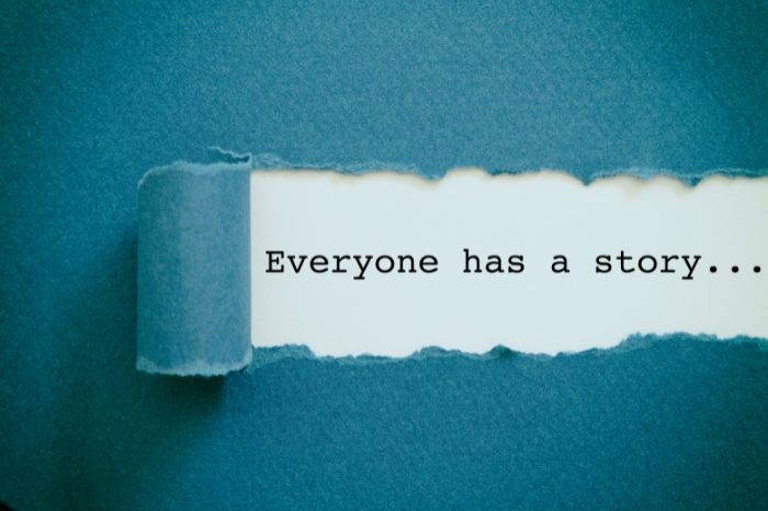 Paper peeling back to reveal the typed phrase: "Everyone has a story ..."